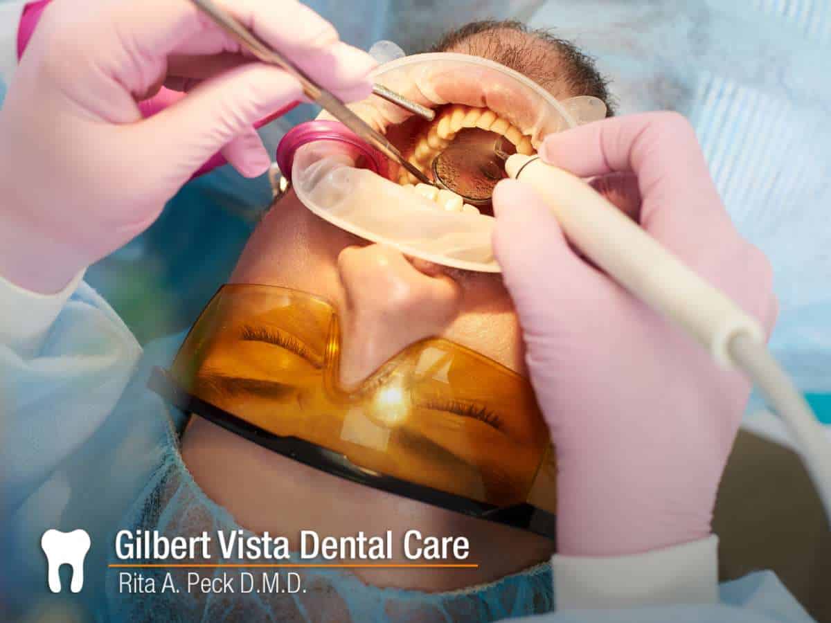 Dental professional applying a filling during a procedure at Gilbert Vista Dental Care