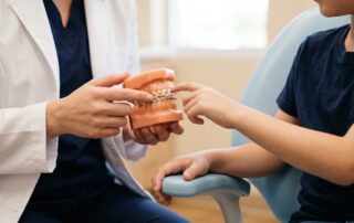 Dentist showing a child a braces model during an orthodontic discussion